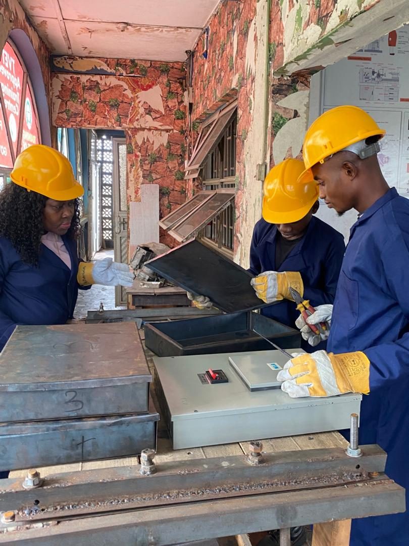 Trainees inspecting a fabricated metal box sample